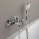 Mischbatterie von Ideal Standard mit integriertem Handbrauseanschluss und flexibler Duschschlauchmontage, montiert an einer hellen Wand.